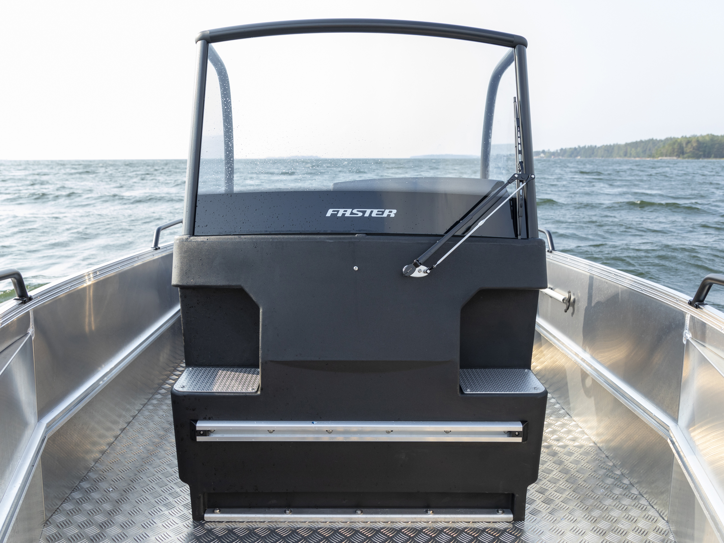 Faster 570 CC -alumiiniveneen ohjauspulpetti kuvattuna edestä. Veneen laidoissa sekä pulpetin etupuolella näkyy Fasterin kätevät varustelukiskot.